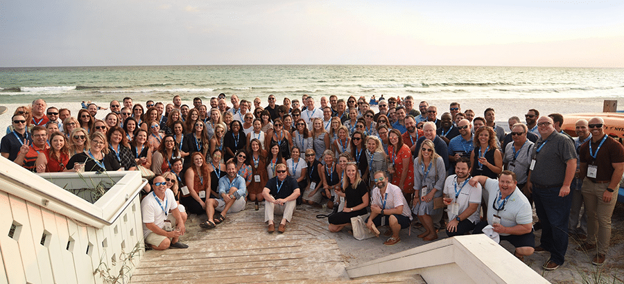 large group of real estate marketing professionals on beach