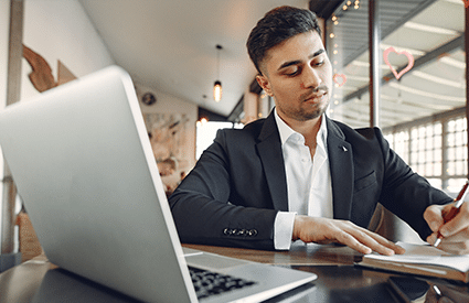 male real estate professional attire working remotely on laptop