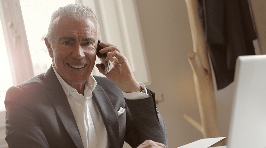 older white male real estate agent in suit on phone