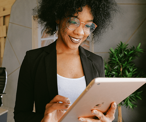 professional black woman with glasses holding tablet accessing dotloop account in office