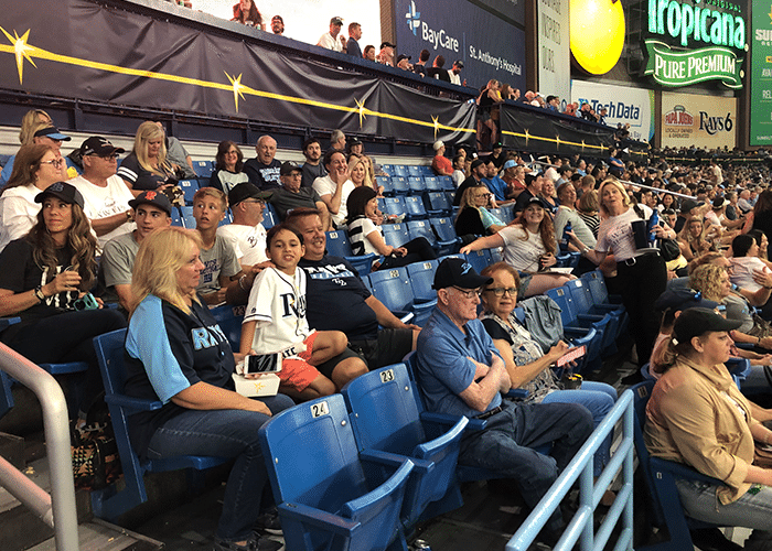 real estate agents and their families sitting in baseball stadium stands in st petersburg florida tampa bay rays game