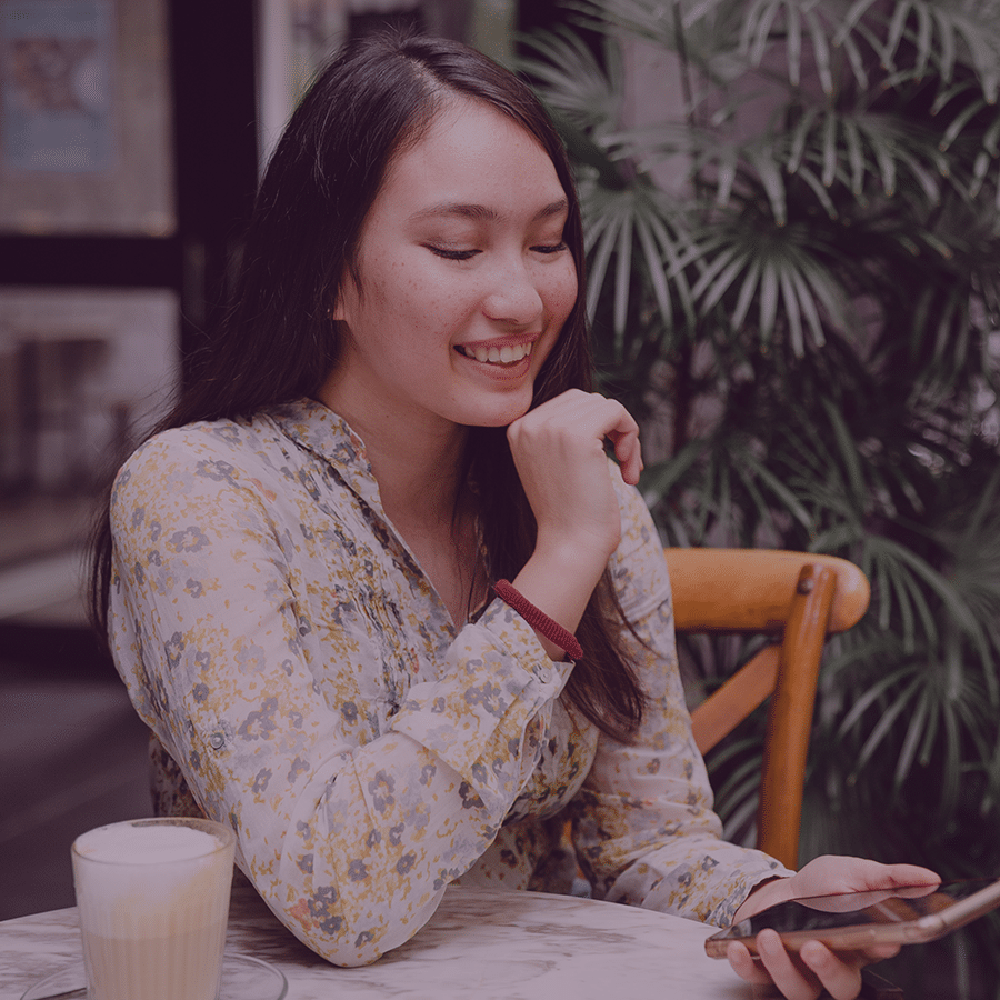 young entrepreneur woman on phone sitting at table smiling