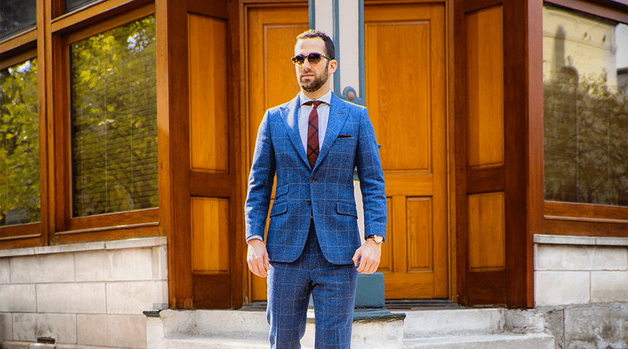 caucasian male real estate agent with beard wearing sunglasses and blue suit