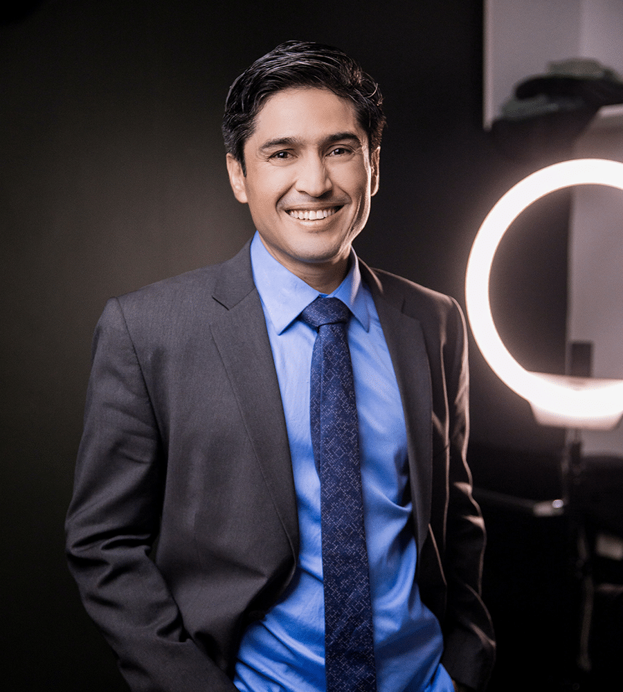 hispanic millennial man dressed in suit and tie taking professional image with ring light