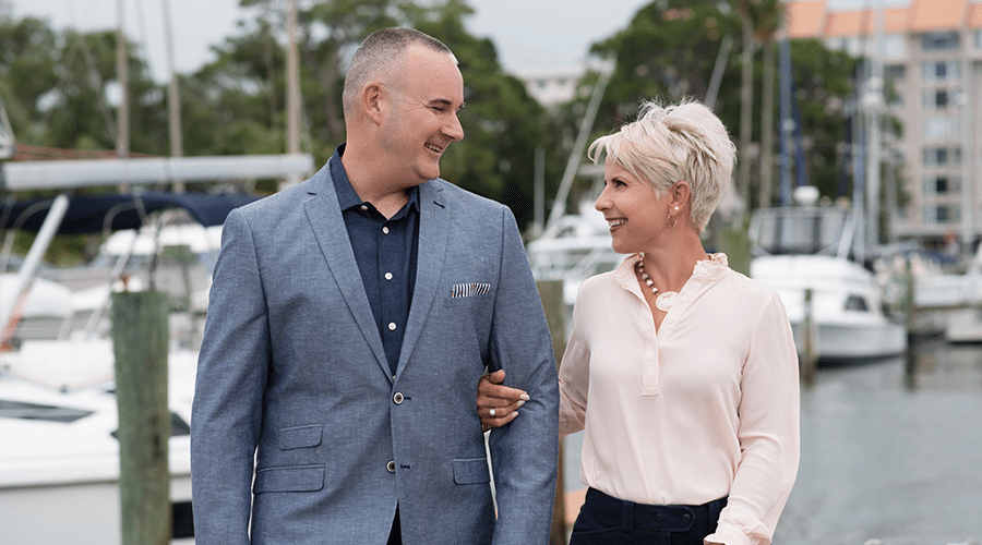 husband and wife real estate agents dressed professionally in boat marina