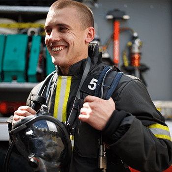 male fire fighter smiling with gear on
