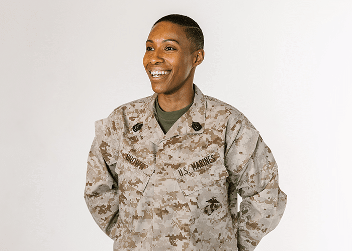 military woman wearing marines uniform with arms behind back and smiling