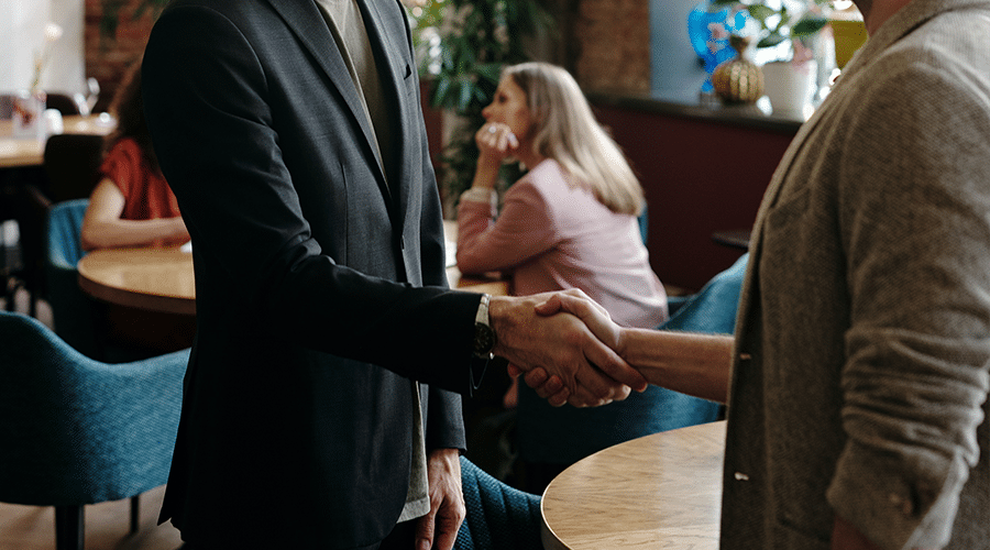 two people shaking hands at coffee shop