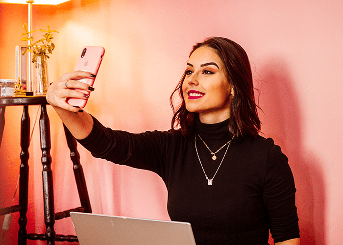young real estate agent woman holding mobile phone taking video for social media